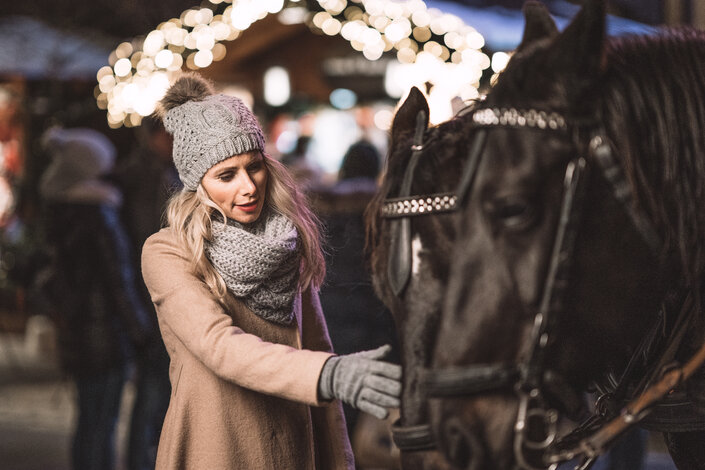 Frau streichelt ein Pferd beim Adventmarkt in St. Wolfgang | © Robert Maybach